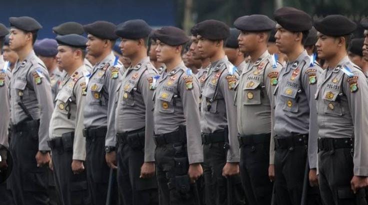 Seorang polisi Indonesia berdiri dengan gagah, memperlihatkan profesionalisme dan keberanian dalam menjalankan tugasnya